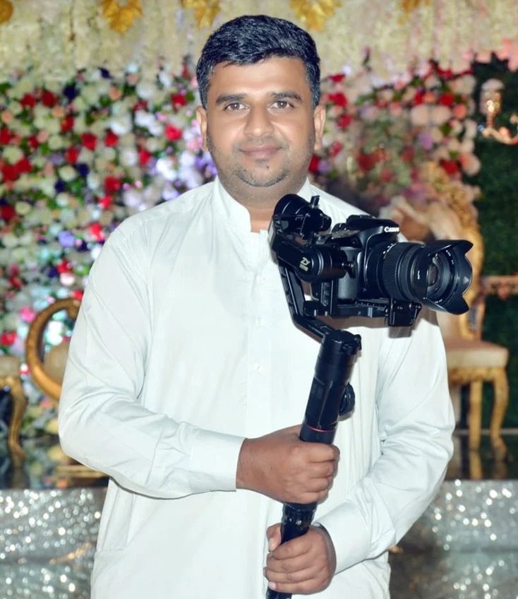 Owner of Zahid Movies Dadyal with his camera at a wedding stage in Dadyal, AJK